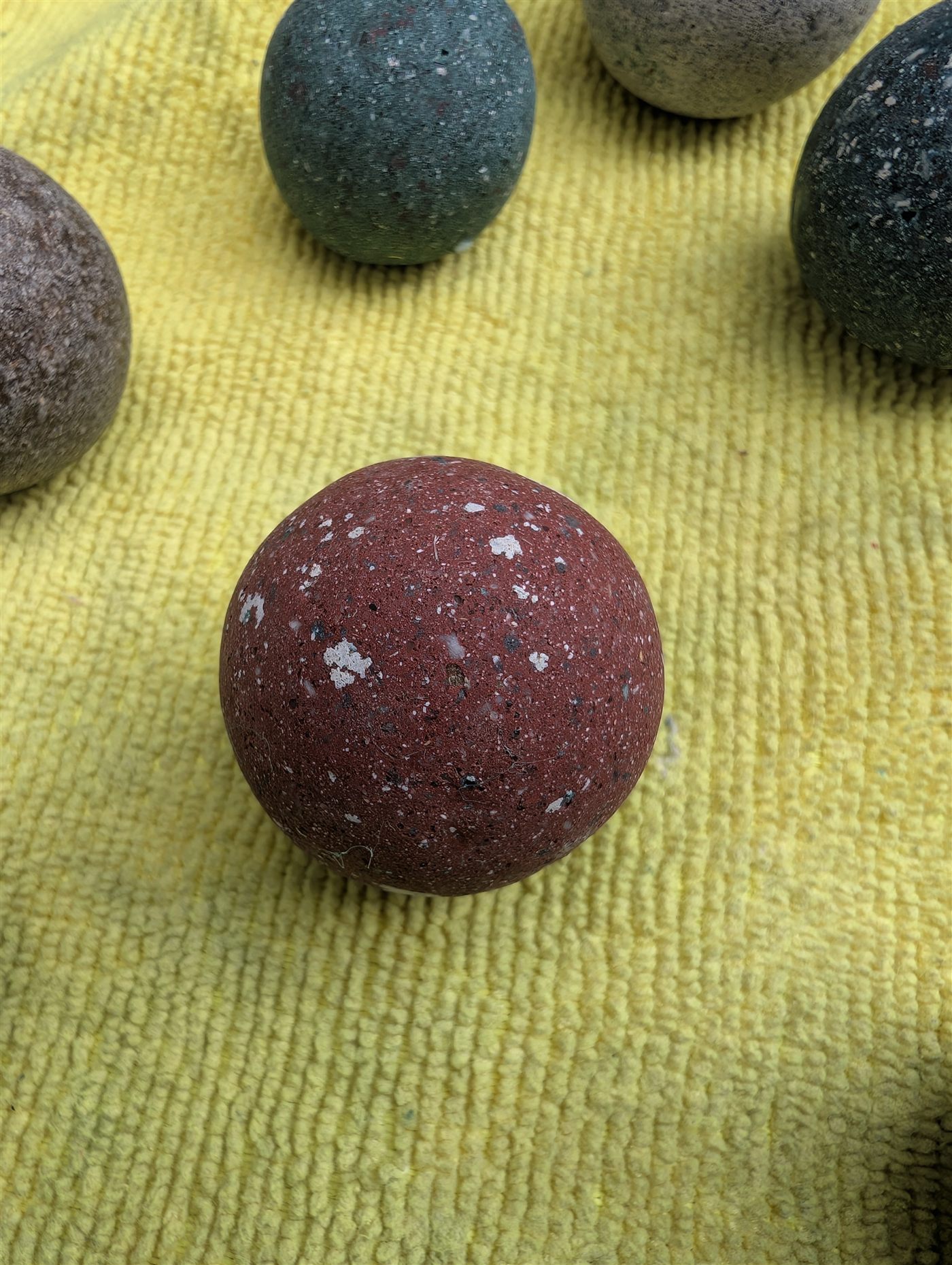 A terracotta-red keepsake orb flecked with white cremains crystals.